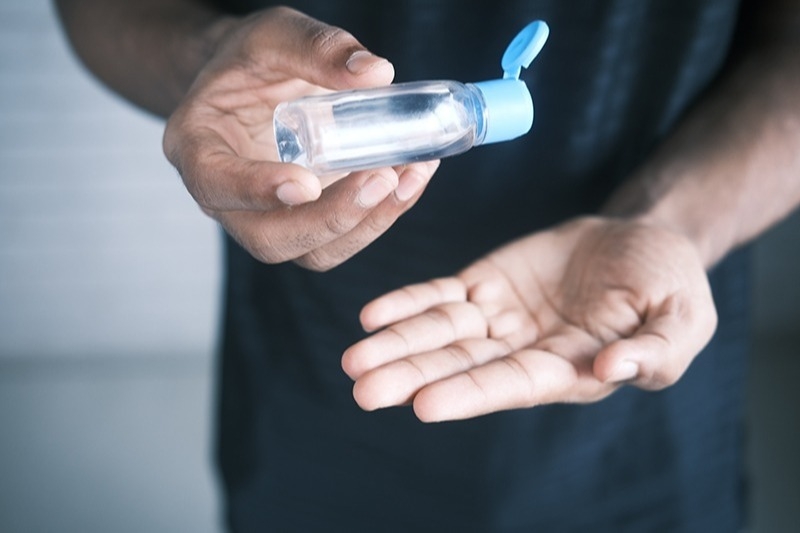 Close up of a person using hand sanitizer on their hands